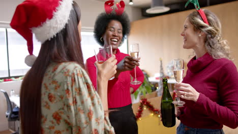 Happy-diverse-female-creative-colleagues-drinking-christmas-toast-in-office,-slow-motion