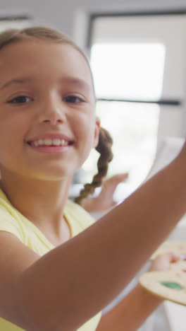 Video-of-smiling-caucasian-girl-painting-during-art-lessons-at-school