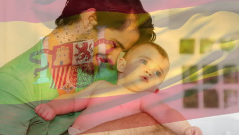 Composite-Video-Einer-Wehenden-Spanischen-Flagge-Vor-Einem-Kaukasischen-Vater,-Der-Sein-Baby-Zu-Hause-Umarmt