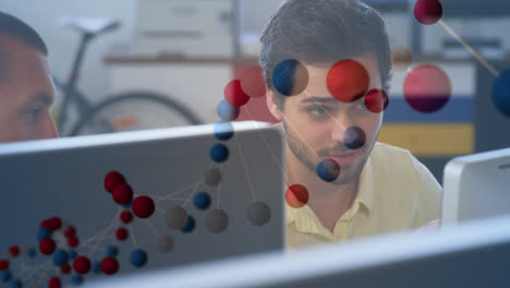 Animation-of-dna-rotating-over-caucasian-man-working-with-computer-in-office