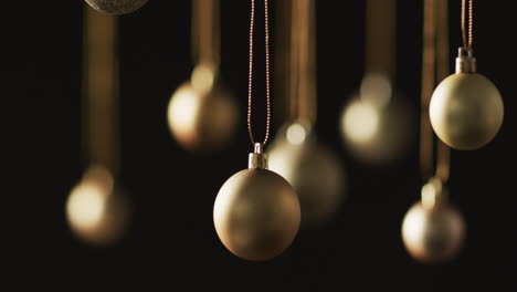 Video-of-gold-baubles-christmas-decorations-with-copy-space-on-black-background