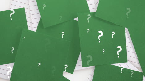 Animation-of-white-question-marks-over-green-sheets-of-paper-and-lined-notebooks