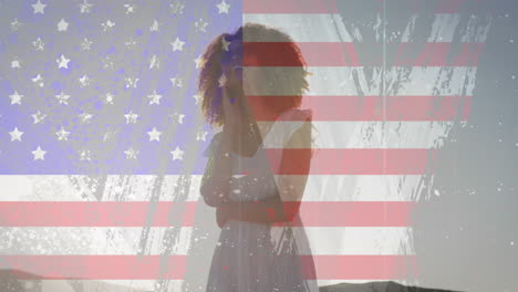 Animation-Des-USA-Flaggeneffekts-Gegen-Eine-Afroamerikanische-Frau,-Die-Am-Strand-Vergnügt-Ist