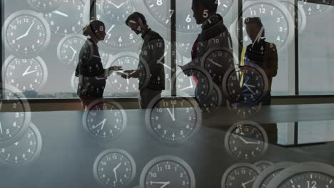 Animation-of-multiple-ticking-clocks-against-view-of-businesspeople-discussing-at-office