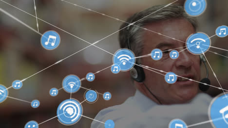 Animation-of-network-of-connections-over-caucasian-businessman-using-phone-headset-in-warehouse
