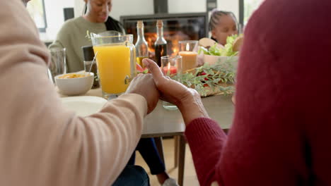 Glückliche-Afroamerikanische-Mehrgenerationenfamilie,-Die-Beim-Thanksgiving-Dinner-Betet,-Zeitlupe