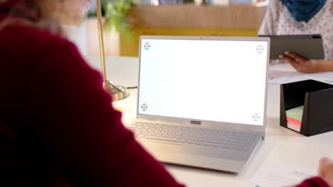 Mujer-De-Negocios-Casual-Caucásica-Usando-Laptop-Con-Espacio-Para-Copiar-En-La-Pantalla-En-La-Oficina,-Cámara-Lenta