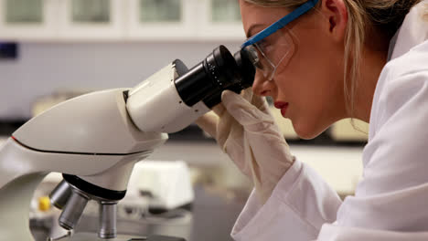Joven-Científico-Mirando-A-Través-Del-Microscopio-En-El-Laboratorio
