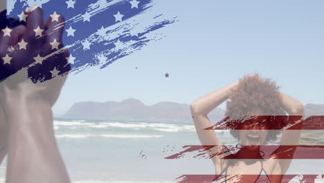 Animation-of-usa-flag-design-against-african-american-man-taking-pictures-of-his-wife-at-the-beach