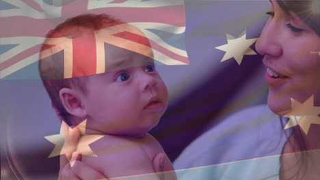 Composite-Video-Einer-Wehenden-Australischen-Flagge-Vor-Einer-Glücklichen-Kaukasischen-Mutter,-Die-Ihr-Kleinkind-Küsst