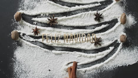Feliz-navidad-text-over-christmas-tree-drawn-in-flour-on-black-background