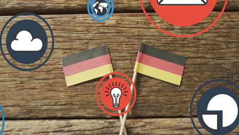 Animation-of-digital-media-icons-over-german-flags-on-wooden-background