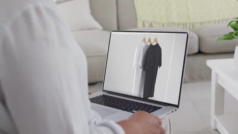 Biracial-Frau-Benutzt-Laptop-Zu-Hause,-Online-Shopping-Für-Kleidung,-Zeitlupe