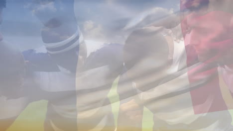 Animation-of-waving-france-flag-against-team-of-diverse-male-rugby-players-discussing-in-a-huddle