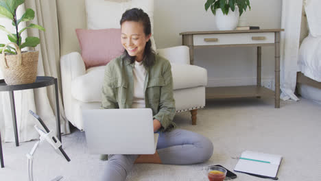 Mujer-Asiática-Feliz-Usando-Laptop-Y-Tableta-En-El-Dormitorio,-En-Cámara-Lenta