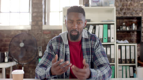 Portrait-of-african-american-casual-businessman-having-video-call-in-office-in-slow-motion