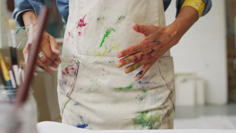 Künstler-Zeigt-Mit-Farbe-Bedeckte-Hände-In-Einem-Kreativstudio