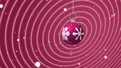 Swinging-pink-and-white-christmas-bauble-over-falling-snow-and-moving-concentric-pink-rings