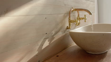 Close-up-of-washbasin-with-running-water-in-bathroom,-slow-motion