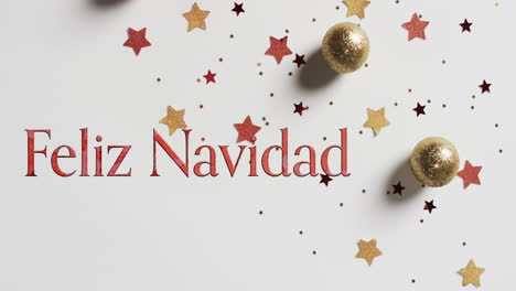 Feliz-Navidad-Text-In-Rot-über-Sternen-Und-Weihnachtskugeln-Auf-Weißem-Hintergrund