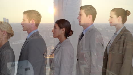 Composite-video-of-group-of-diverse-businesspeople-standing-in-a-queue-against-view-of-cityscape