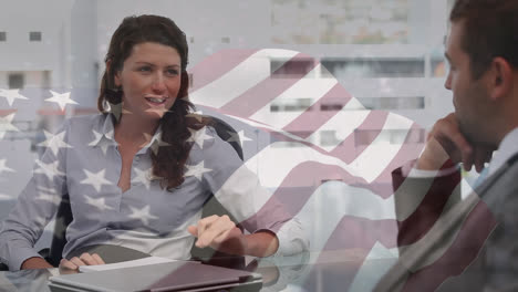 Schwenkende-Amerikanische-Flagge-Gegen-Verschiedene-Geschäftsleute-Und-Geschäftsfrauen,-Die-Im-Büro-Diskutieren