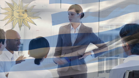 Wehende-Uruguay-Flagge-Gegen-Kaukasische-Senior-Geschäftsfrau,-Die-Im-Büro-Eine-Präsentation-Hält