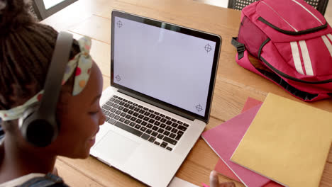 Glückliches-Afroamerikanisches-Mädchen-Im-Online-Unterricht-Mit-Kopfhörern-Und-Laptop-Mit-Kopierraum,-Zeitlupe