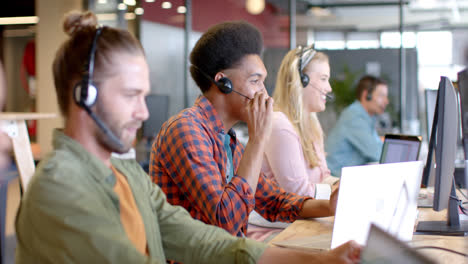 Happy-biracial-casual-businessman-and-diverse-colleagues-using-phone-headsets,-slow-motion