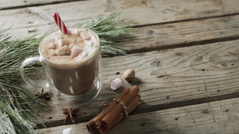 Video-of-glass-of-christmas-chocolate-with-marshmallows-and-copy-space-on-wooden-background