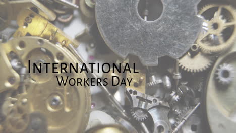 Animation-of-international-workers-day-text-over-tools-and-mechanism-parts