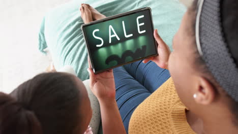 African-american-mother-and-daughter-using-tablet,-online-shopping-during-sale,-slow-motion