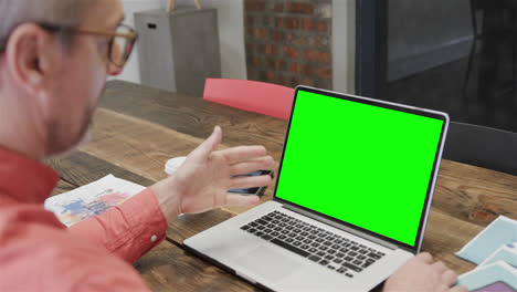 Caucasian-businessman-on-laptop-video-call-with-green-screen