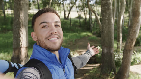 Portrait-of-happy-african-american-man-hiking-in-forest,-copy-space,-slow-motion
