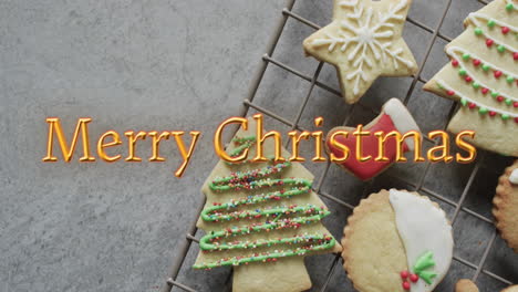 Merry-christmas-text-in-orange-over-decorated-on-christmas-cookies