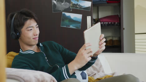 Asiatischer-Junge-Mit-Digitalem-Tablet-Sitzt-Zu-Hause-Auf-Der-Couch