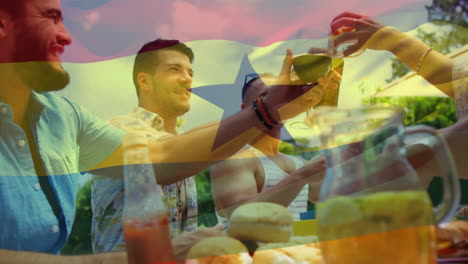 Composite-video-of-ghana-flag-over-diverse-friends-toasting-drinks-while-having-lunch-in-the-park