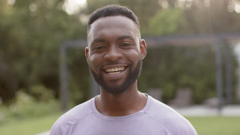 Retrato-De-Un-Hombre-Afroamericano-Feliz-Sonriendo-En-El-Jardín,-En-Cámara-Lenta