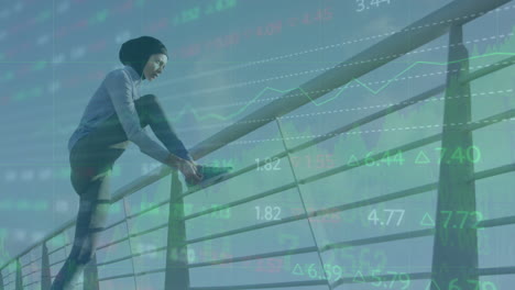 Animation-of-stock-market-data-processing-over-biracial-woman-in-hijab-tying-shoe-laces-on-bridge