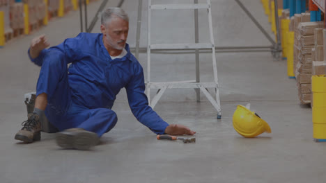 Animation-of-scratches-over-caucasian-senior-man-falling-from-ladder-in-warehouse