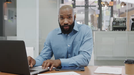 Portrait-of-african-american-businessman-using-laptop,-making-video-call-in-office,-slow-motion