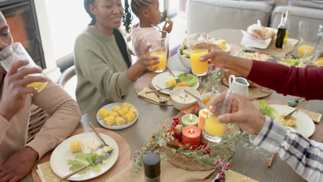 Fröhliche-Afroamerikanische-Mehrgenerationenfamilie,-Die-Beim-Thanksgiving-Dinner-Anstößt,-Zeitlupe