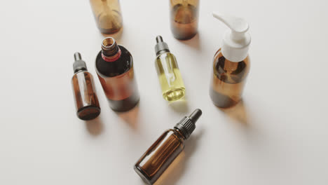 High-angle-view-of-glass-bottles-with-copy-space-on-white-background