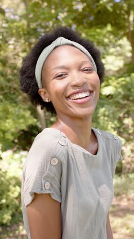 Vídeo-Vertical-De-Retrato-De-Una-Feliz-Mujer-Afroamericana-En-El-Jardín,-En-Cámara-Lenta