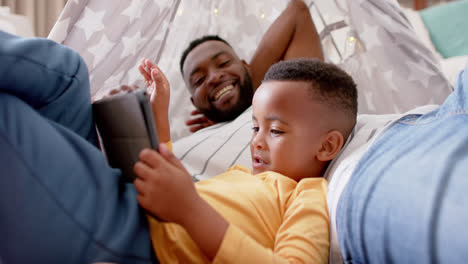 Feliz-Padre-E-Hijo-Afroamericanos-Usando-Tableta-Y-Chocando-Los-Cinco-En-Casa,-Cámara-Lenta