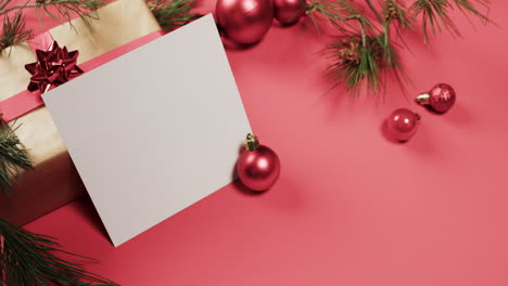 Video-Von-Weihnachtsdekorationen-Und-Weißer-Karte-Mit-Kopierplatz-Auf-Rotem-Hintergrund