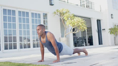 Hombre-Birracial-Enfocado-Practicando-Yoga-En-Un-Jardín-Soleado,-Cámara-Lenta