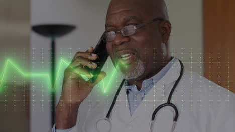 Animation-of-heart-rate-monitor-over-african-american-male-doctor-talking-on-smartphone-at-hospital