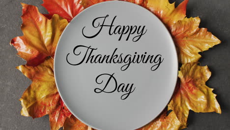 Animation-of-happy-thanksgiving-day-text-and-plate-over-autumn-leaves-background