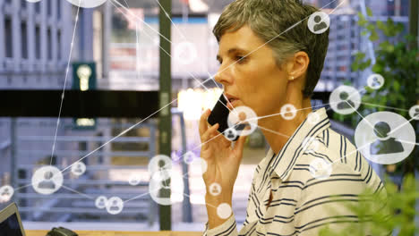 Animation-of-profile-icons-connecting-with-lines-over-caucasian-businesswoman-talking-over-cellphone